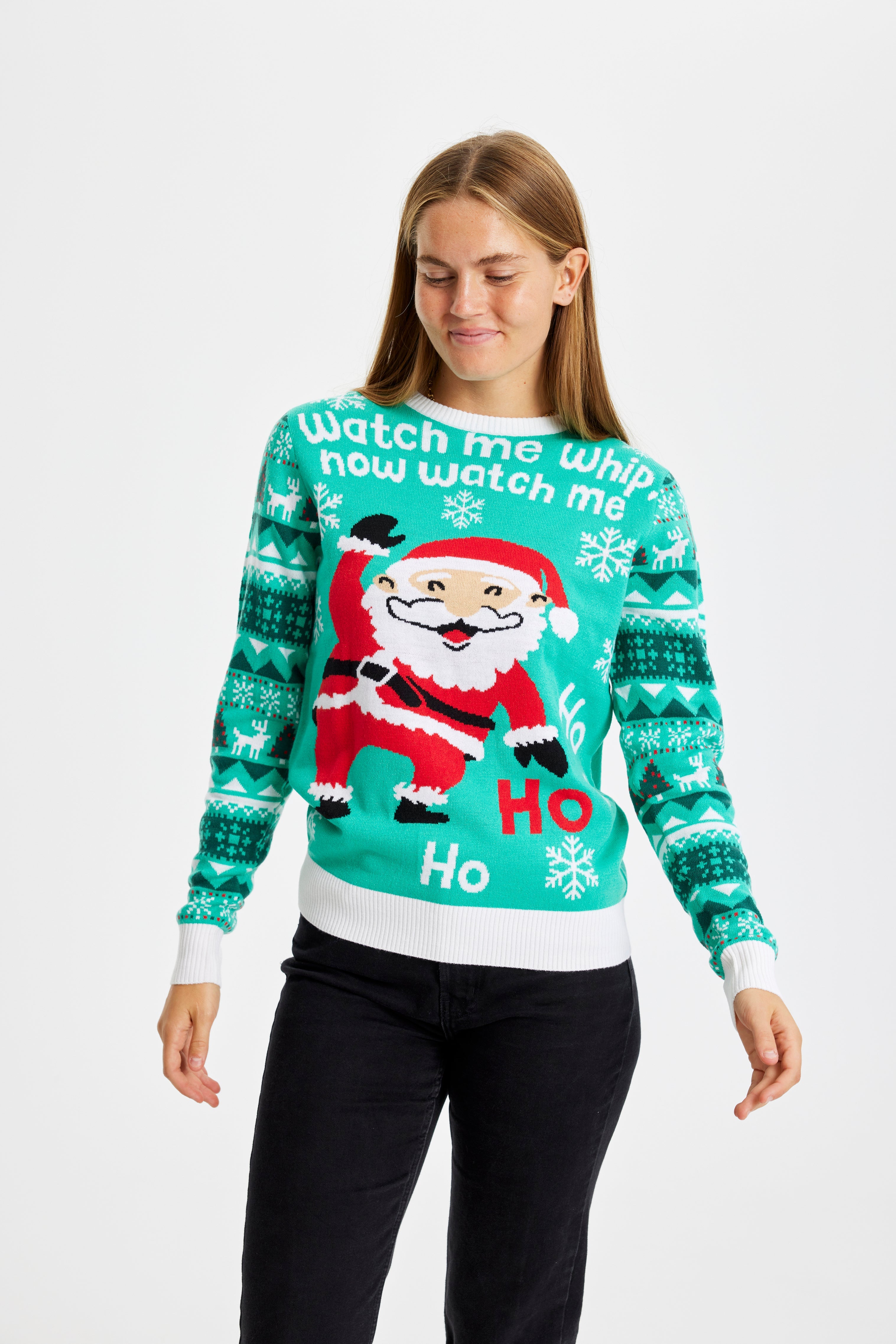 En kvinde kigger ned og er iført en julesweater.